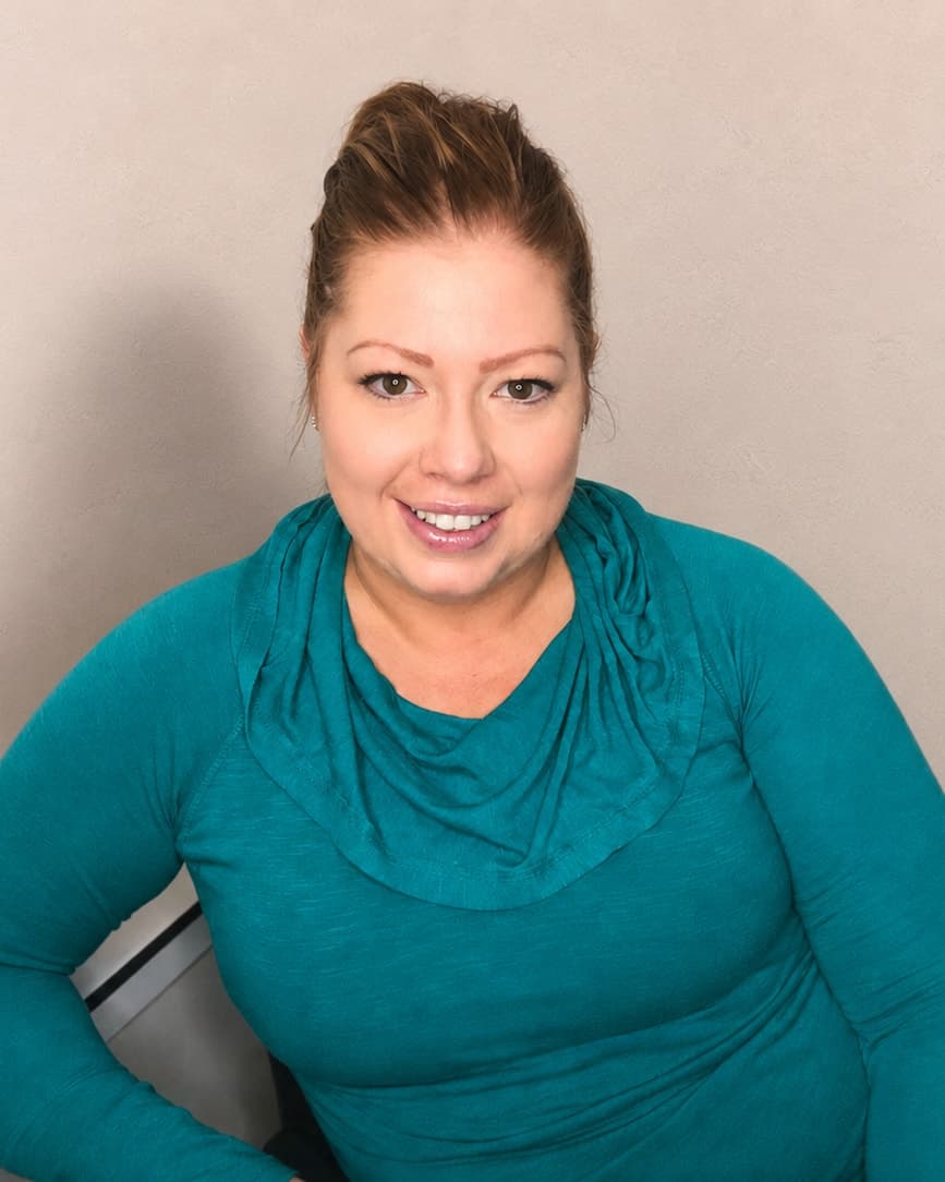 Racheal Blackmore smiling at her desk, wearing a teal top.