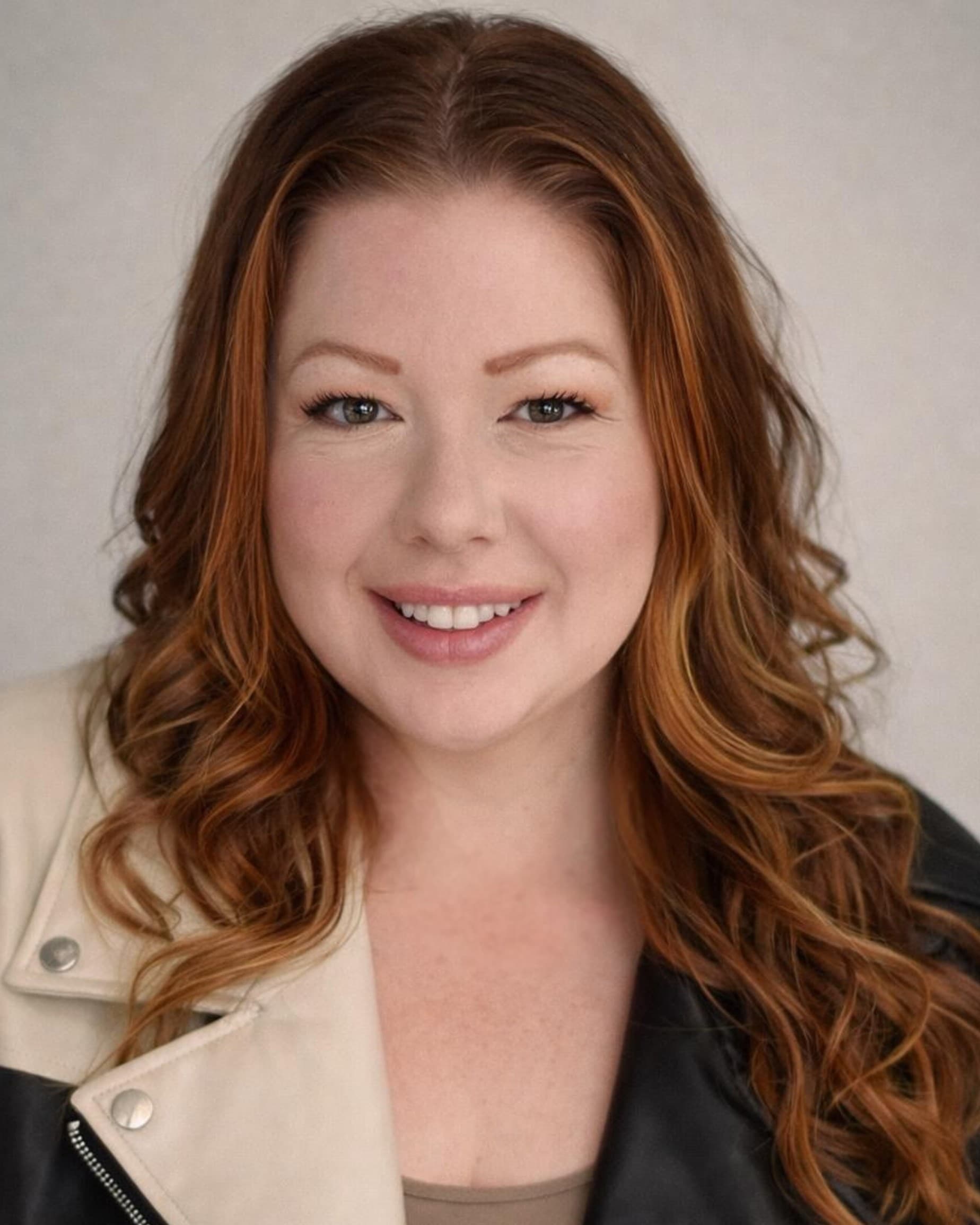 Racheal Blackmore, smiling, wearing a black and cream leather jacket.
