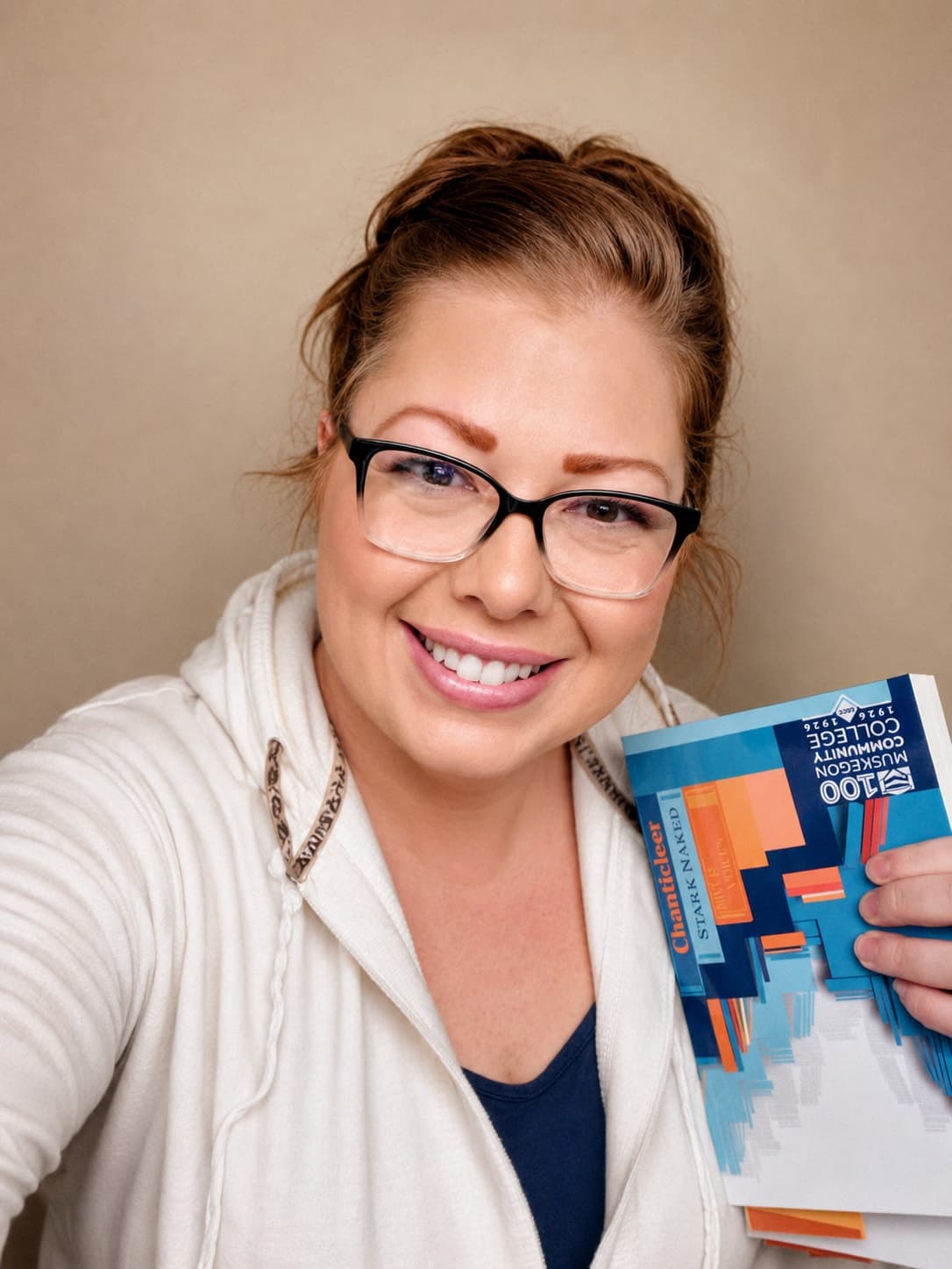 Racheal Blackmore smiling and holding the River Voices Spring 2025 journal.